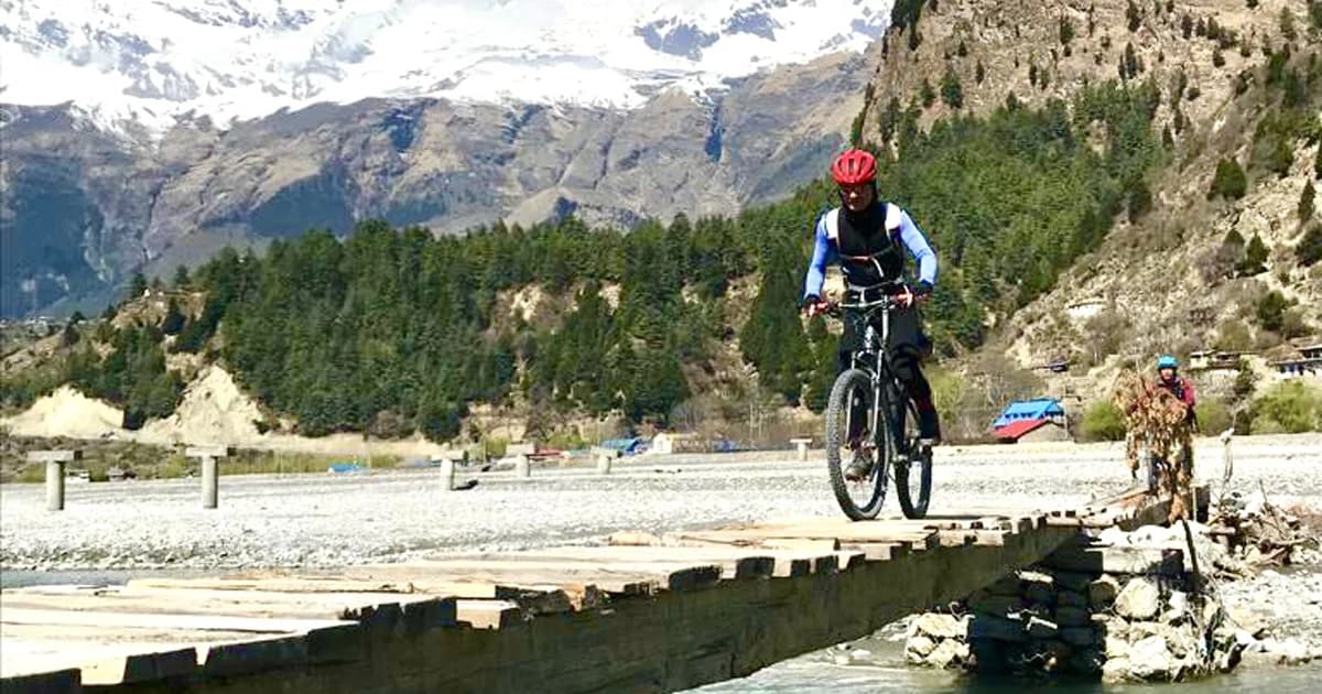 mountain bike tour passing through the local wooden bridge