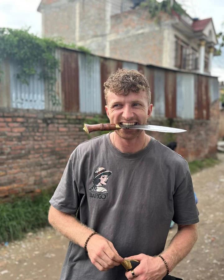 Tourist holding Gurkha knife in his mouth